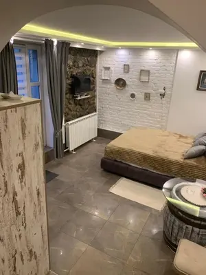 a bedroom with a bed and a stone wall at Apartman Nina BANOVO BRDO in Belgrade