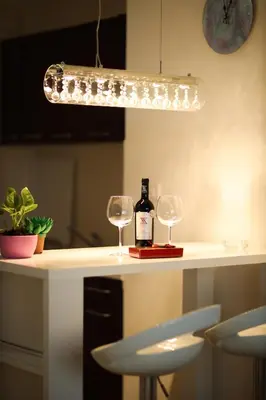 a bottle of wine and two wine glasses on a counter at Apartman Lux in Nova Pazova