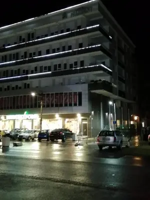 a parking lot in front of a building at night at Apartman Lux in Nova Pazova