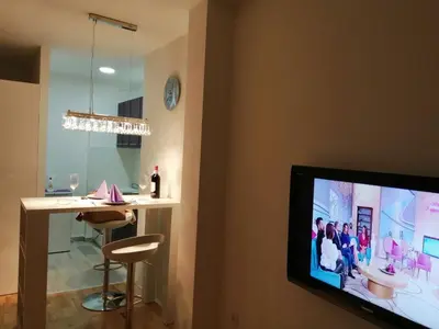 a living room with a tv and a bar at Apartman Lux in Nova Pazova