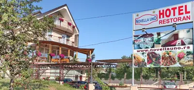 a hotel with a sign in front of a building at Hotel Novella Uno in Novi Banovci