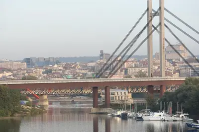 a bridge over a river with boats in the water at Hotel Novella Uno in Novi Banovci