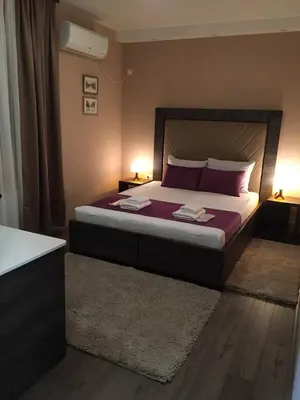 a bedroom with a large bed with purple pillows at Luxury Apartments 88 in Smederevo