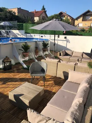 a patio with couches and an umbrella and a pool at Luxury Apartments 88 in Smederevo