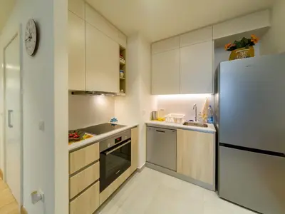 a kitchen with white cabinets and a refrigerator at Apartment Rebecca in Belgrade