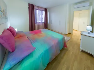 a large bed with a colorful comforter in a bedroom at Apartment Rebecca in Belgrade