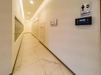 a hallway with a tile floor and a sign on a wall at Apartment Rebecca in Belgrade