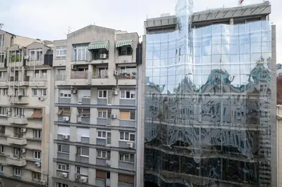 a building reflected in the glass of a building at Selection Rooms in Belgrade