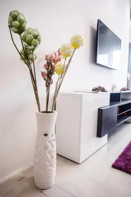 a white vase with flowers in a living room at Apartman Niki in Arandjelovac