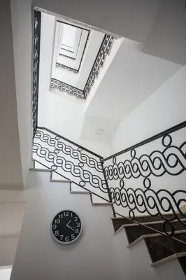 a clock sitting on the floor next to a staircase at Apartman Niki in Arandjelovac