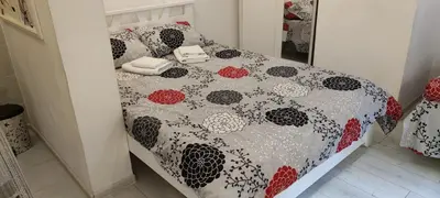 a bed with a comforter and pillows on it at Studio Apartman KOCKA in Belgrade