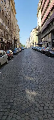 a cobblestone street with parked cars in a city at Studio Apartman KOCKA in Belgrade