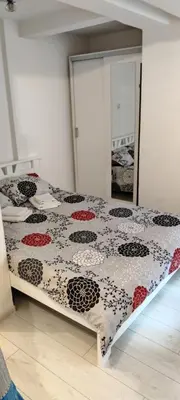 a bedroom with a bed with a black and red quilt at Studio Apartman KOCKA in Belgrade
