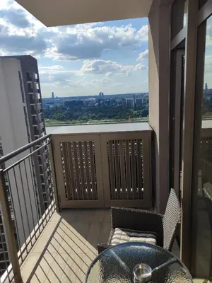 a balcony with a table and chairs on a building at Belgrade Waterfront Comfortable Apartment in Belgrade