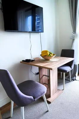 a wooden table with a bowl of bananas on it at Belgrade Waterfront Comfortable Apartment in Belgrade