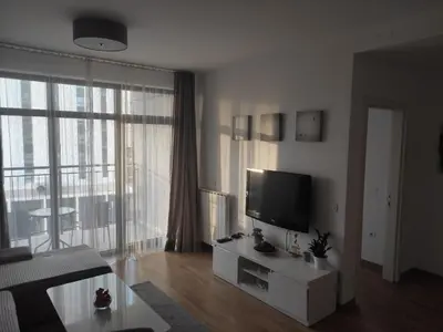 a living room with a tv and a large window at Belgrade Waterfront Comfortable Apartment in Belgrade