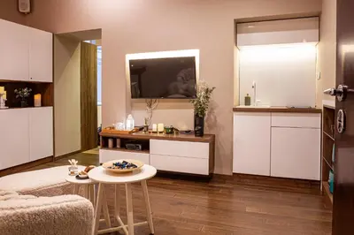 a living room with a kitchen with white cabinets at VENUS Apartment with jacuzzi and sauna - City Center in Belgrade
