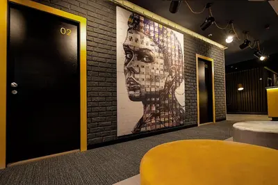 a large painting of a woman on a brick wall at Maccani Black Luxury Suites in Belgrade