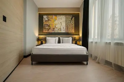 a bedroom with a bed and a painting on the wall at Maccani Black Luxury Suites in Belgrade