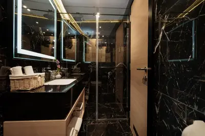 a bathroom with two sinks and a shower at Maccani Black Luxury Suites in Belgrade