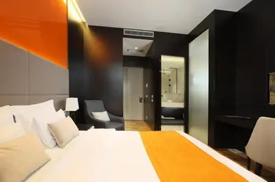 a bedroom with a large white bed and a desk at Maccani Black Luxury Suites in Belgrade