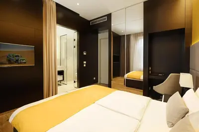 a bedroom with a large bed and a mirror at Maccani Black Luxury Suites in Belgrade