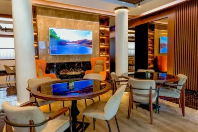 a lobby with two tables and chairs and a painting on the wall at Nobel Gallery Hotel in Belgrade