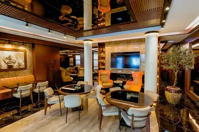 a restaurant with tables and chairs and a television at Nobel Gallery Hotel in Belgrade
