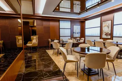 a restaurant with tables and chairs and windows at Nobel Gallery Hotel in Belgrade