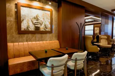 a restaurant with two tables and chairs and a painting on the wall at Nobel Gallery Hotel in Belgrade