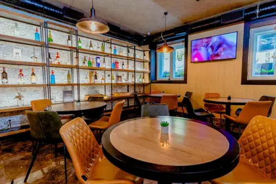 a dining room with tables and chairs and a tv at Nobel Gallery Hotel in Belgrade