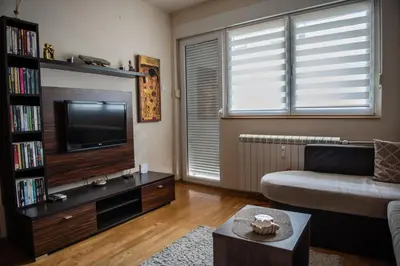 a living room with a couch and a television at The Temple bells, flat in the heart of the city in Dušanovac (historical)