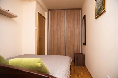 a bedroom with a bed and a wooden closet at The Temple bells, flat in the heart of the city in Dušanovac (historical)
