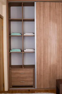 a closet with wooden shelves and folded towels at The Temple bells, flat in the heart of the city in Dušanovac (historical)