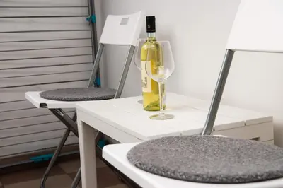 a bottle of wine sitting on a table with two chairs at The Temple bells, flat in the heart of the city in Dušanovac (historical)