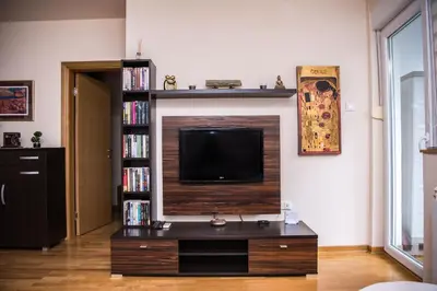 a living room with a tv and a book shelf at The Temple bells, flat in the heart of the city in Dušanovac (historical)