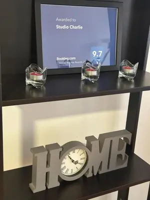 a clock on a shelf with a tv and a sign at Charlie Aviv Park in Belgrade