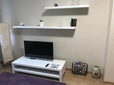 a living room with a tv on a white table at TD City Center Apartment in Belgrade