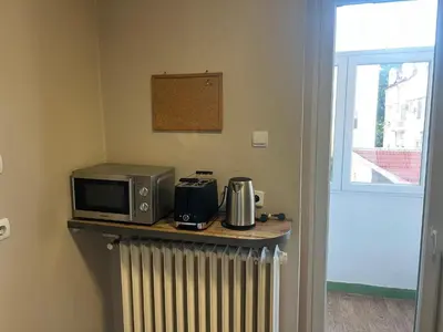 a microwave and coffee maker on a counter with a heater at TD City Center Apartment in Belgrade