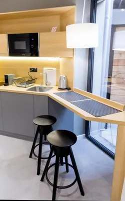 a kitchen with two stools at a counter with a sink at Teanna Lux Apartments in Belgrade