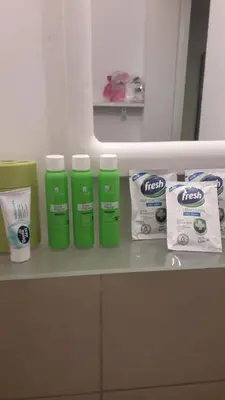 a shelf with four bottles of facial products and two bags at Apartman Pocerac in Belgrade