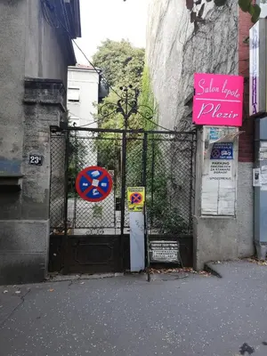 a gate with a sign in front of a building at Apartman Pocerac in Belgrade
