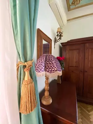 a lamp sitting on a table next to a curtain at Apartments HOUSE OF THE GREATS Skadarlija in Belgrade