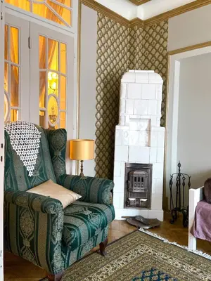 a living room with a green chair and a fireplace at Apartments HOUSE OF THE GREATS Skadarlija in Belgrade