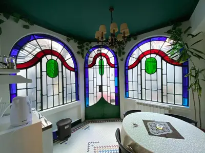 a room with four stained glass windows and a table at Apartments HOUSE OF THE GREATS Skadarlija in Belgrade