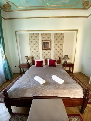 a bedroom with a large bed with red pillows at Apartments HOUSE OF THE GREATS Skadarlija in Belgrade