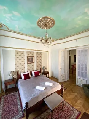 a bedroom with a bed and a chandelier at Apartments HOUSE OF THE GREATS Skadarlija in Belgrade