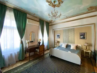 a bedroom with a bed and a desk and a chandelier at Apartments HOUSE OF THE GREATS Skadarlija in Belgrade