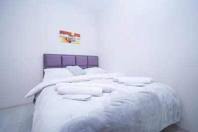 a large white bed with white blankets and pillows at Cvetni trg in Belgrade