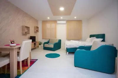 a living room with a bed and a table and chairs at Cvetni trg in Belgrade